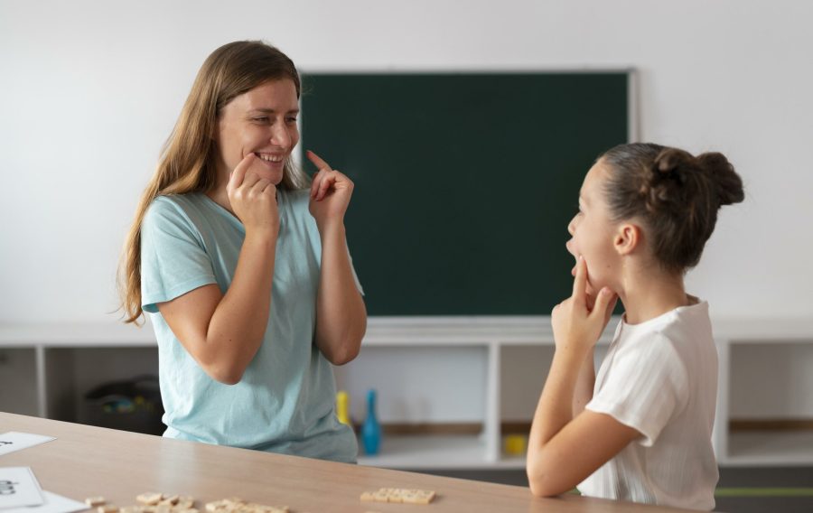 psychologist-helping-girl-in-speech-therapy-scaled